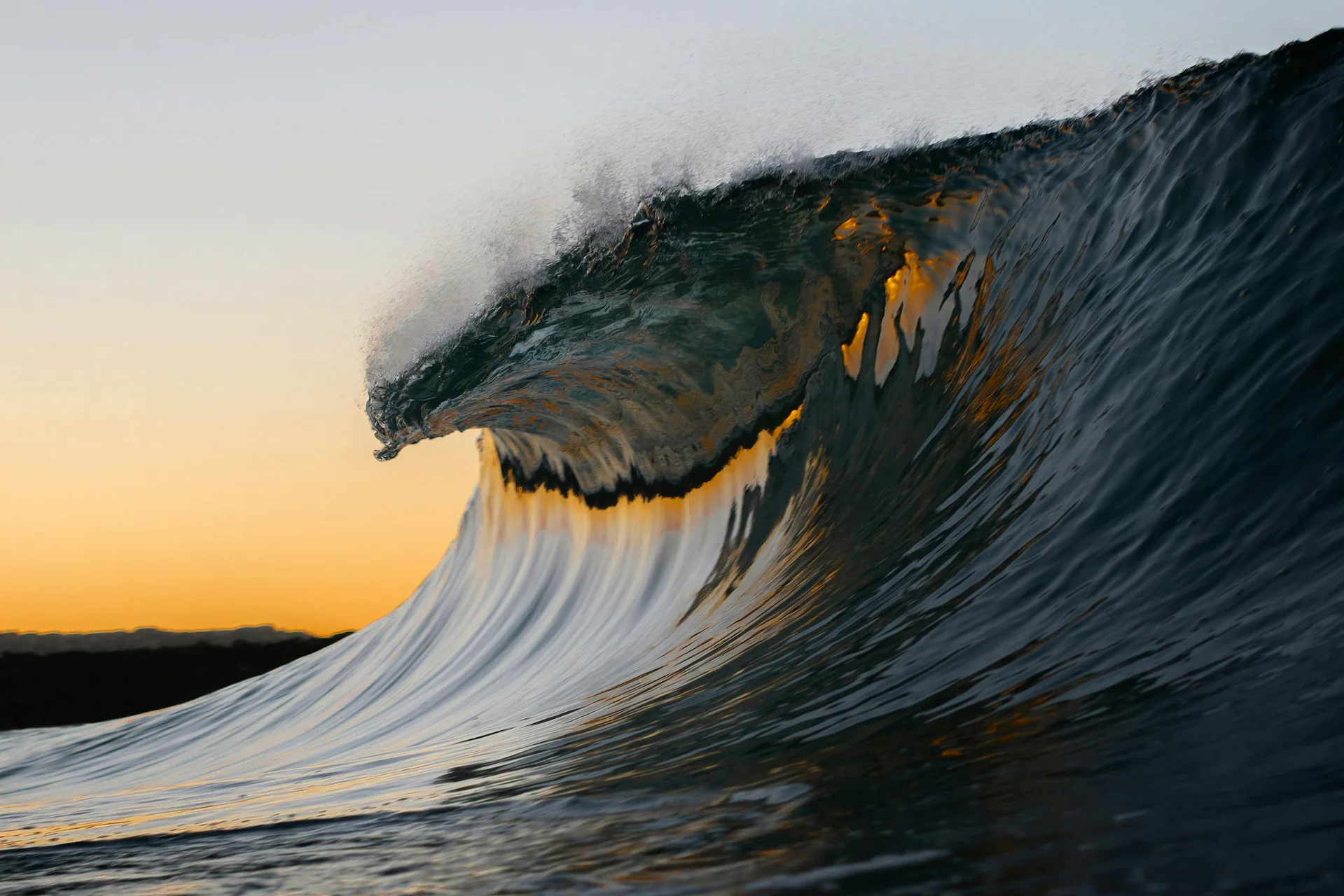 Ocean wave breaking at sunset